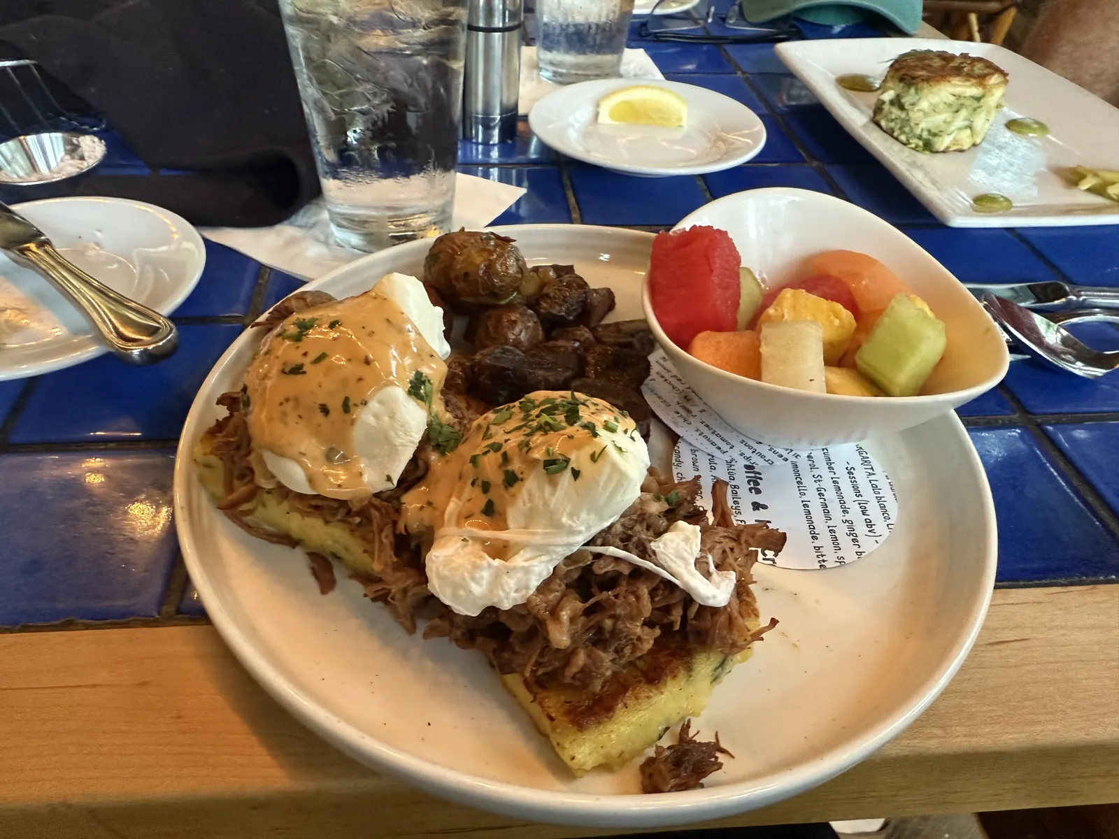 Eggs Benedict brunch plate with fresh fruit